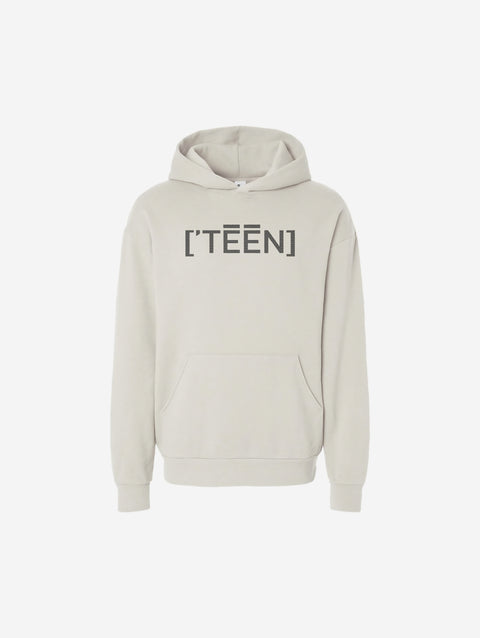 A bone-colored off-white hoodie with the bold text "[‘TĒĒN]" in black, minimalist design, featuring a pullover style.
