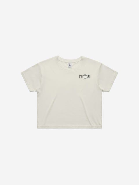 A bone-colored cropped T-shirt featuring the minimalist "['LIT·TLE] Life" logo on the left chest.
