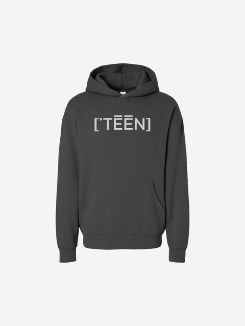 A gray-toned charcoal hoodie with the bold text "[‘TĒĒN]" in white, minimalist design, featuring a pullover style.
